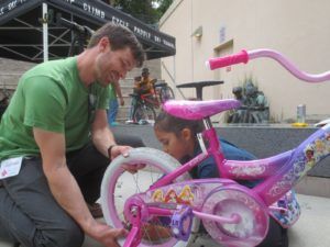 young girl with bicycle at Fixit Clinic getting repair help