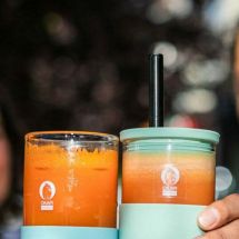 couple holding OKAPI reusable beverage containers