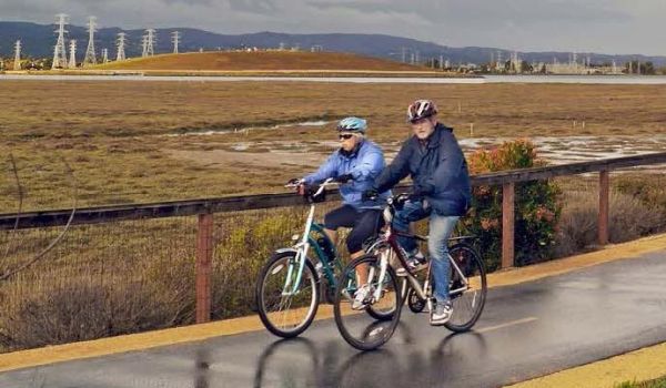 senior couple riding bicycles on paved Half Moon Bay Coastal Trail