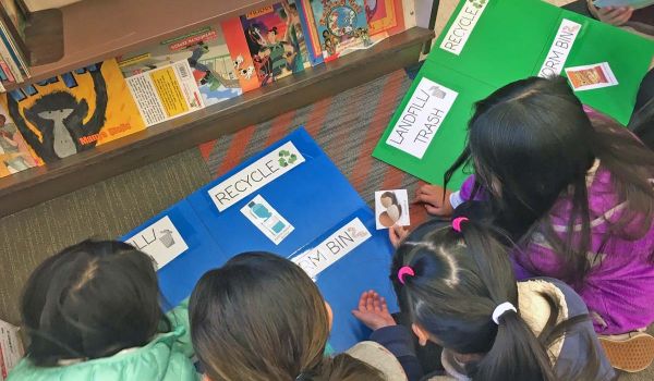 four young students playing San Mateo County 4R's game - reduce, reuse, recycle, rot for compost