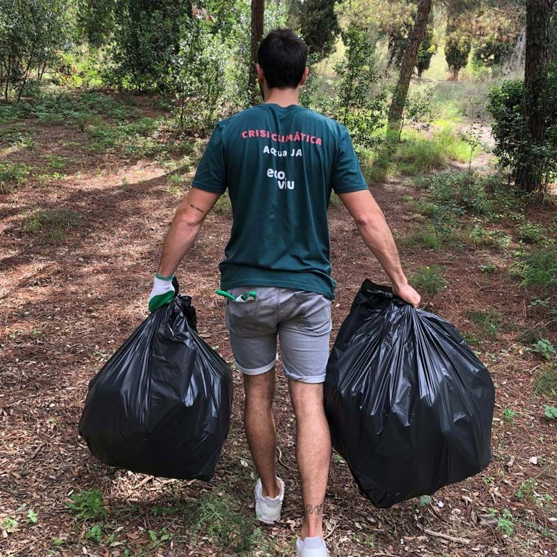 man carrying bags of trash doing community clean up