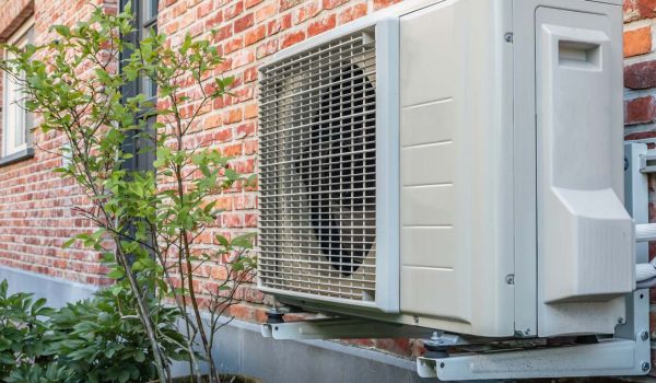 electric heat pump mounted to home exterior wall