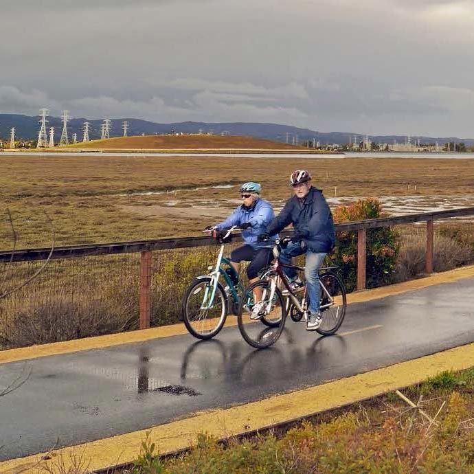senior couple riding bicycles on paved Half Moon Bay Coastal Trail