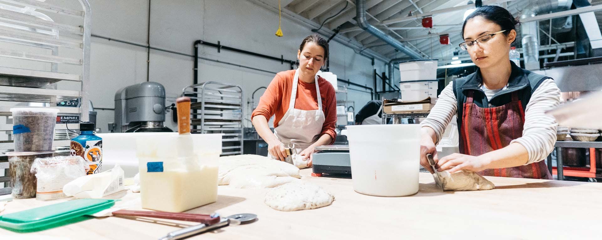 two women baking bread in commercial kitchen
